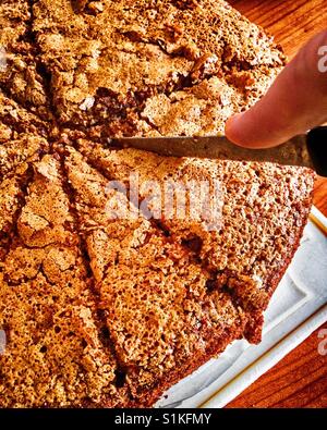 Woman hand with knife cutting homemade carrot cake