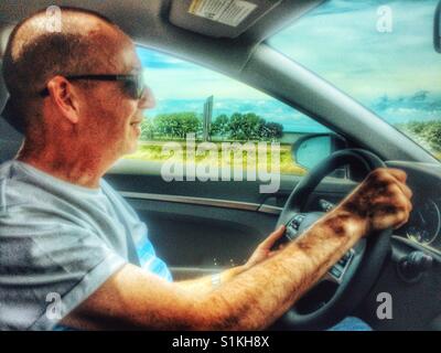 Middle aged man driving left hand drive car, Canada Stock Photo