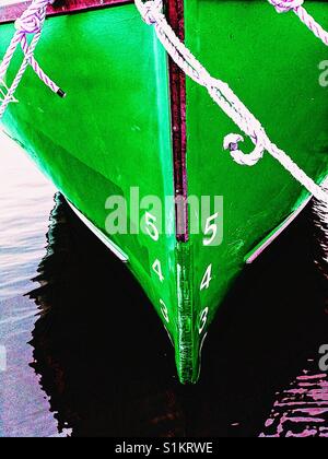 Ship's draft on green hull of moored ship. The vertical distance between the waterline and the bottom of the hull. Stock Photo