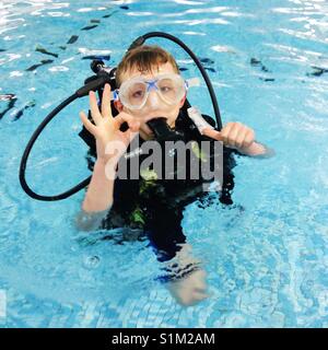 Eight year old boy scuba diving in a swimming pool. Stock Photo
