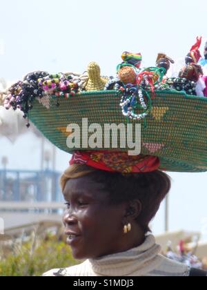 A Beautiful Souvenir Seller Carrying Her For Sale Items On Her Head In Cape Verde...x Stock Photo