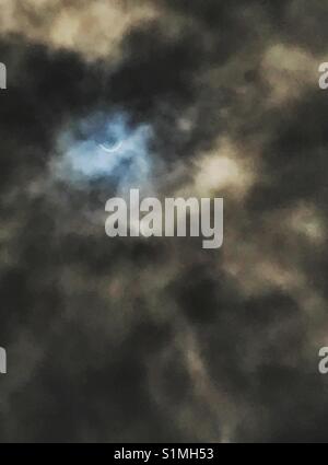 Solar eclipse visible through hazy dark clouds, Jacksonville, Florida, August 21, 2017 Stock Photo