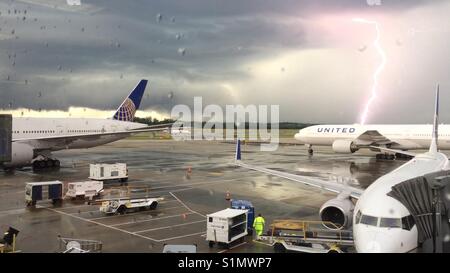 Lightning strike over Washington Dulles airport as United Airlines planes wait the storm to pass Stock Photo