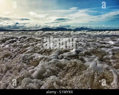 Tide rushing into shore at Newborough beach on Anglesey Stock Photo