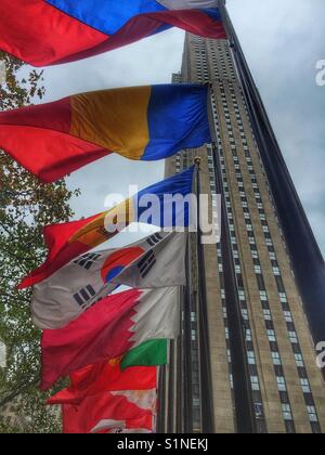 The flags of world countries fly at the Rockefeller Center with the Rockefeller building in the background, New York City, New York. Stock Photo