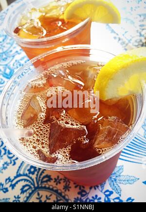 Two plastic iced tea glasses with Black Bear Diner logo on a table; a