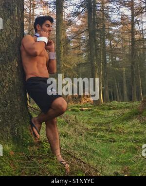 Man getting dressed in the woods Stock Photo