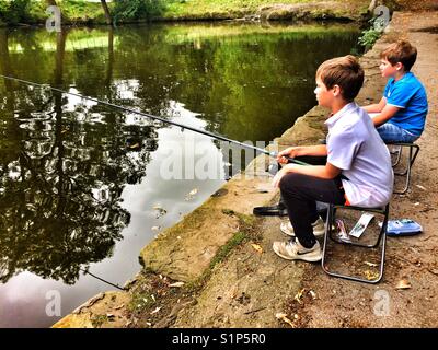 Two boys fishing in lake Stock Photo