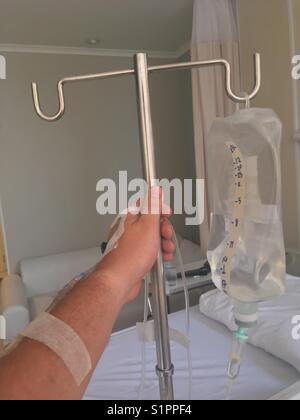 Man holds drop counter in Hospital room Stock Photo