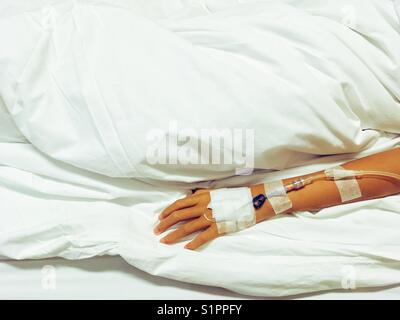 Arm of small Asian girl with injection of medicine drop counter in Hospital room on bed Stock Photo