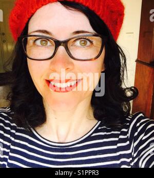 Woman wearing hat and glasses smiling Stock Photo