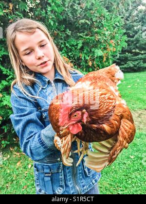 Girl holding chicken Stock Photo