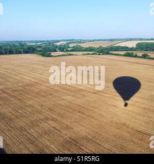 Hot air balloon shadow in field Stock Photo