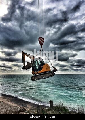 Digger being lowered to the beach at Birling Gap during step replacement. Stock Photo