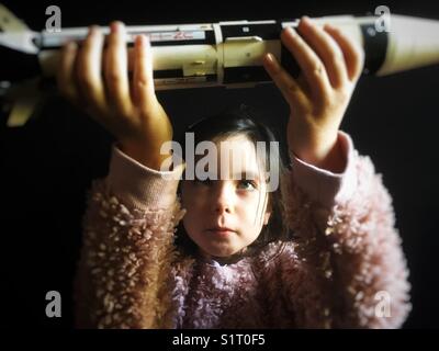 Young girl holding a model of the Saturn IB Apollo 7 space rocket Stock Photo