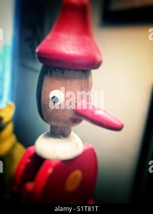 Somebody knows something (vintage wooden pull toy with interesting painted facial expression) Stock Photo