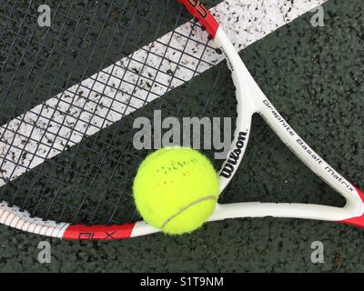 Tennis ball and racket on court Stock Photo