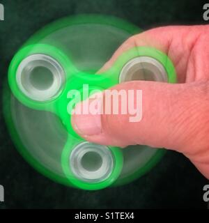 Green fidget spinner in action Stock Photo