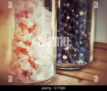 Closeup of Himalayan pink rock salt and black peppercorns in glass grinders Stock Photo