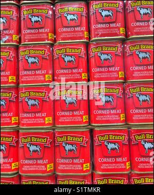 Tins of corned meat on supermarket shelf. Stock Photo