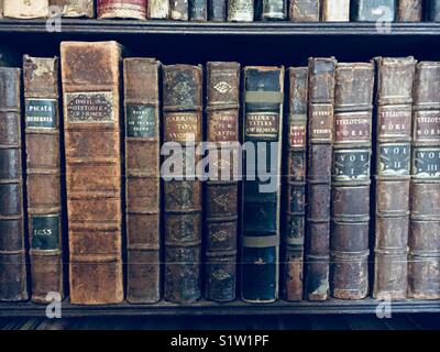 Antique books on an old library shelf Stock Photo