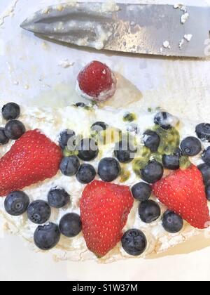 Half eaten pavlova cake view from above. Pavlova is the traditional Christmas cake in Australia. Stock Photo