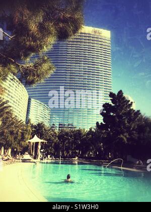 Man swimming in one of the oval heated pools at Aria Resort and Hotel in Las Vegas in December Stock Photo