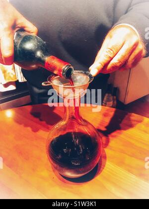 Decanting a 1996 Chateau d’Angludet, appellation Margaux controller, bottle of red wine from bottle to decanter to remove any sediment. Stock Photo