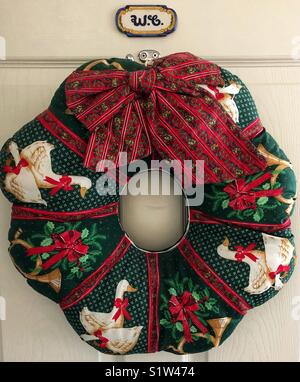 Quilted Christmas wreath hanging on a door. Stock Photo