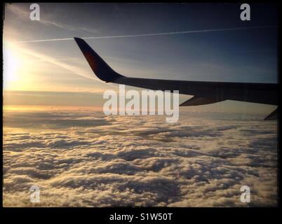 Sunrise above the clouds as seen from a Jet2 flight en-route to Spain. Stock Photo
