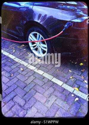 Electric car being recharged in street, Netherlands Stock Photo