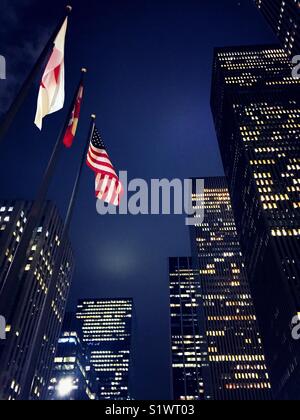 Nation flags and skyscrapers along Avenue of the Americas at dusk, NYC Stock Photo