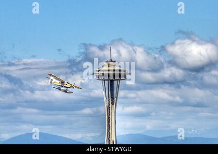 Seaplane from Kenmore air flying past the space needle in Seattle Washington on its approach to Lake Union Stock Photo