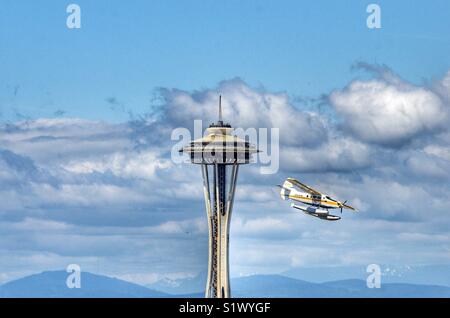 Seaplane from Kenmore air flying past the space needle in Seattle Washington on it’s landing approach to Lake Union Stock Photo