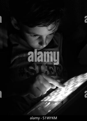 Young boy playing chess on tablet Stock Photo
