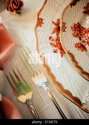 Table setting of fine china plates and sterling silver flatware Stock Photo