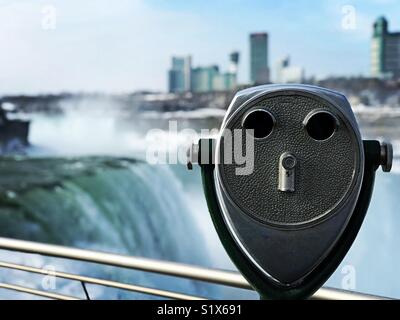 Frozen Niagara Falls in winter on American side. Canada is opposite. It’s the end of January, and Niagara Falls State Park is empty. Maid of the Mist and tourist binocular. Stock Photo