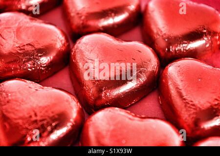 Heart shaped chocolates wrapped in red foil Stock Photo