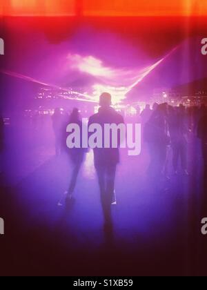 Abstract of people walking into a foggy lighting display Stock Photo