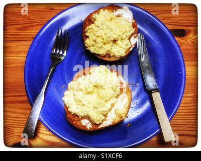 Scrambled eggs on toasted bread roll Stock Photo