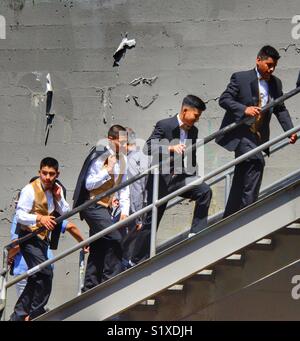 Group of similarly Nicely dressed man walking up the stairs after attending a wedding ceremony Stock Photo