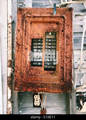 Rusty old electrical circuit breaker box on the exterior of an abandoned beach home in Florida, USA. Stock Photo