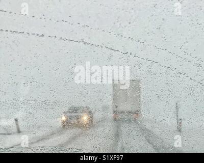 Car driving in heavy snow. A front window view of bad weather conditions Stock Photo