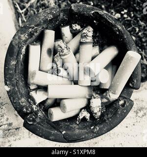 Cigarette ends in ashtray - black and white ph Stock Photo