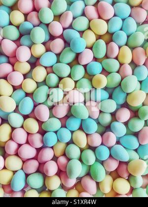Pink, green, blue, and yellow sugar-coated chocolate mini eggs. Stock Photo