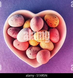 chocolate Easter eggs in a ceramic heart shaped dish Stock Photo