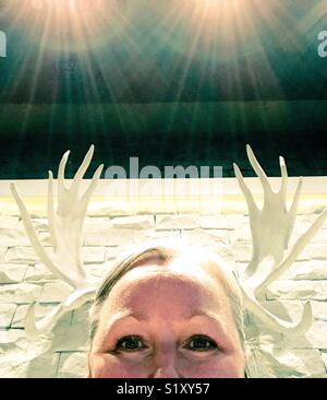 A curious perspective on wall decor creates the illusion of wearing antlers. Stock Photo