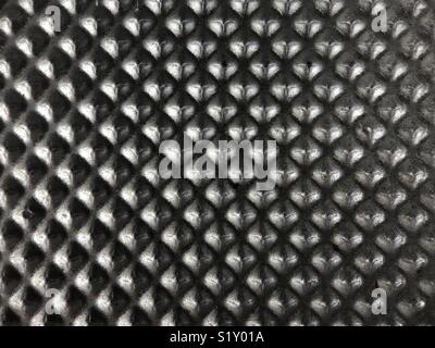 Small pyramids of a die-cast metal plate are shown up close. Stock Photo