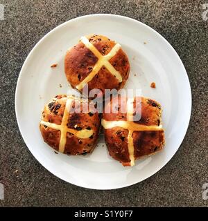 Toasted hot cross buns on a white plate, ready for eating. Stock Photo