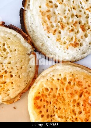 Three buttered, toasted English crumpets. Stock Photo